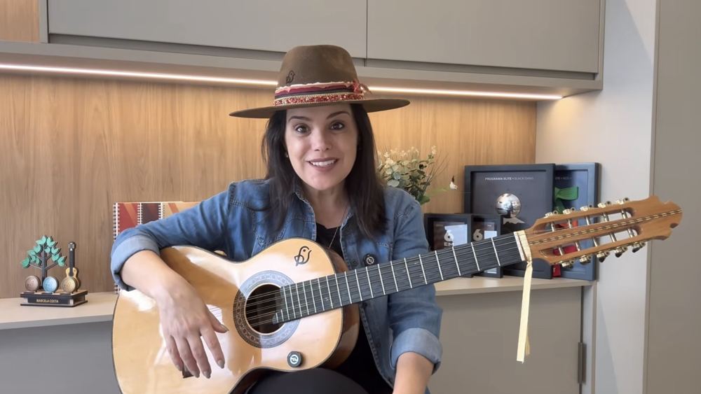 Marcela Costa tocando viola caipira durante a aula de pagode de viola